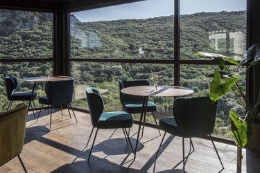 La salle du restaurant offre une vue spectaculaire sur les collines et le lac des Olivettes.