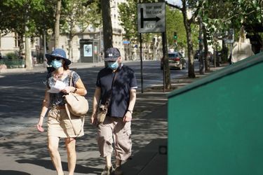 Des badauds masqués à Paris , le 15 août. 