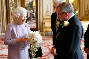La reine Elizabeth II le 30 mai 2013 avec une réplique de son bouquet de couronnement contenant du muguet, sa fleur préférée 