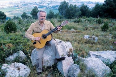 Sur les hauteurs de Sète en juin 1978, avec sa panoplie de chanteur poète : guitare à la main et pipe posée sur le rocher.