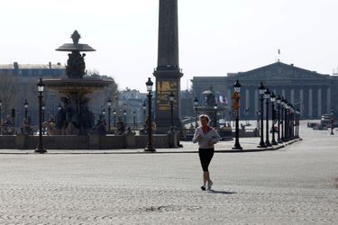 Place de la Concorde, une Parisienne fait son jogging dans la ville déserte. 