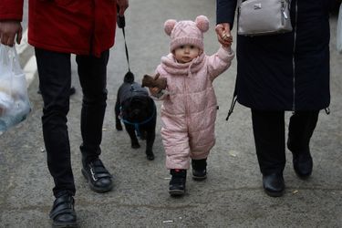 Des Ukrainiens marchent avec un enfant après avoir traversé la frontière entre la Pologne et l'Ukraine.