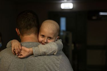 Un enfant dont le traitement contre la leucémie est en cours, embrasse son père alors qu'il marche le long des couloirs du sous-sol de l'hôpital pour enfants Okhmadet, à Kiev.