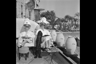 Le 8ème Festival de CANNES se déroule du 26 avril au 10 mai 1955. Les deux Brigitte de Cannes : Brigitte FOSSEY (8 ans et demi) et Brigitte BARDOT (20 ans) ont fait connaissance chez le coiffeur. La seconde est accompagnée de &quot;Clown&quot;, son cocker.