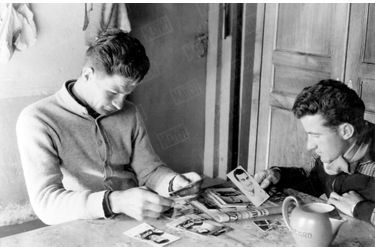 Raymond Poulidor et son frère passent en revue les photos de presse du champion en devenir, en mars 1961.