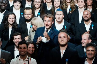 Emmanuel et Brigitte Macron posent pour une photo de groupe avec les médaillés olympiques et paralympiques de Tokyo. 