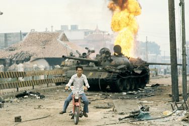 La fuite, par tous les moyens. Devant un char russe en feu près de l’aéroport, où les parachutistes sud-vietnamiens ont résisté.