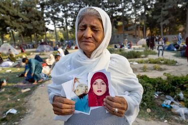 Zoohra, 60 ans, tient deux photos de sa fille tuée un mois plus tôt, dit-elle, par les talibans. Le 12 août, dans un camp de fortune pour les Afghans déplacés par le conflit, au parc Shahr-e Naw, à Kaboul.