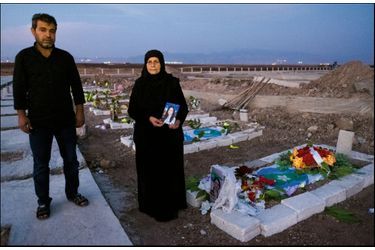 Cimetière de Derik, Rojava. Sadia Khalaf, accompagnée de son fils Adil, devant la tombe de sa fille Hevrin, tuée avec son chauffeur le 12 octobre.
