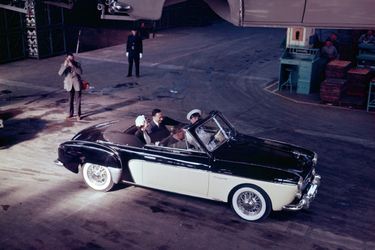 À Flins, le 10 avril 1957, la Reine visite les usines Renault, assise à l’arrière d’une décapotable.