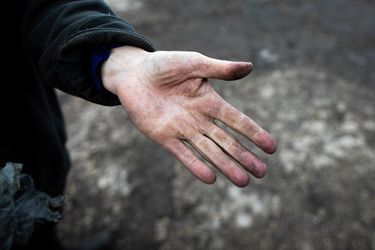 Un agriculteur montre sa main qui porte des traces de suie, près de Rouen.