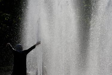 Un homme profite des fontaines du Trocadéro à Paris pour se rafraîchir. 