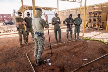 Le bac à sable. Un lieutenant du 1er RPIMa trace un croquis devant trois commandants de section maliens
