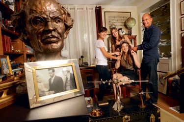 Portraits de famille. Derrière le buste d’Auguste Piccard et la photo des trois générations en 1960, Bertrand et ses fi lles en 2011 (de g. à dr.), Solange, Oriane et Estelle.