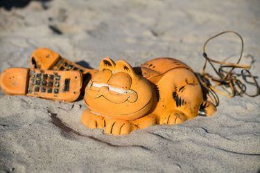 Un téléphone Garfield ensablé sur une plage bretonne.