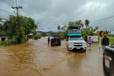 Des personnes tentent d&#039;avancer sur une route inondée dans la province de Loei en Thaïlande le 2 août 2020