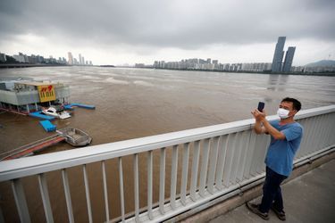 Un homme prend une photo au-dessus du fleuve Han à Séoul en Corée du Sud après des inondations le 6 août 2020