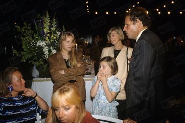 Patrick Poivre d&#039;Arvor, entouré de son épouse Véronique et de ses filles Morgane, 9 ans, et Solenn, 15 ans, lors de la réception donnée pour ses dix ans de présentation du 20H, aux serres d&#039;Auteuil en juillet 1990.