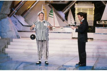 Coluche aux côtés de Michel Drucker, sur le plateau de l'émission "Champs-Élysées", en juillet 1985.