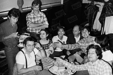 Coluche lors d'une pause sandwich-frites-bières, entre les répétitions de sa pièce "Ginette Lacaze 1960" à l'Elysée Montmartre, avec sa nouvelle troupe - Martin Lamotte, Josiane Balasko, Myriam Mézières, Patrick Olivier, Michel Puterflam, Thierry Lhermitte, Gérard Lanvin et Christian Clavier - en octobre 1976.