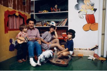 Coluche lors d'une séance photo en famille, avec son épouse Véronique et leurs fils Marius, 4 ans, et Romain, 8 ans, chez eux, rue Gazan, près du parc Montsouris, dans le XIVe arrondissement de Paris, en octobre 1980.