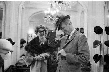 James Stewart essaie des chapeaux sous le regard amusé de son épouse Gloria, lors d’un passage à Paris en novembre 1959.