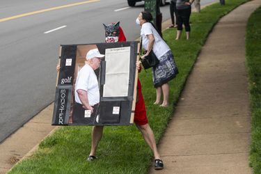 Dimanche à Sterling, en Virginie, une manifestante brandit un montage montrant Donald Trump face à la Une du «New York Times», qui montrait ce jour-là les noms de 1000 des près de 100 000 victimes du coronavirus aux Etats-Unis.