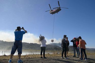 Des curieux admirent le ballet des hélicoptères bombardiers d'eau à Yountville, en Californie, samedi.