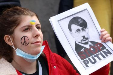 Un manifestant tient une affiche lors d'une manifestation anti-guerre devant le Parlement européen pour soutenir l'Ukraine dans le cadre de l'invasion russe, à Bruxelles. 