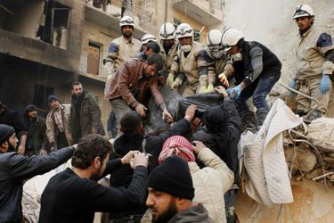 A Alep, ces rebelles syriens enlèvent un corps des débris causés par une attaque aérienne. 