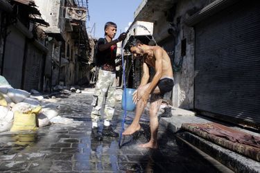  Ce rebelle prend un douche dehors, dans le vieil Alep. 