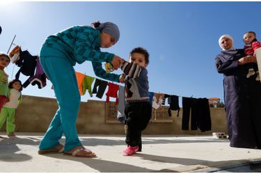 Un jeune réfugié syrien soupçonné d&#039;avoir la polio aidé par sa soeur pour marcher, dans le camp de Chebaa, au Liban.