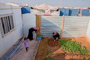 Brahim, 27 ans, avec sa femme et sa fille dans le petit potager qu’il a aménagé près de sa « caravane ».