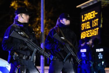 Deux policières allemandes mardi 17 novembre à Hanovre, devant un panneau indiquant que &quot;le match international est annulé&quot;.