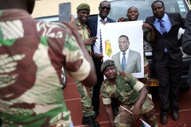 Des militaires zimbabwéens tiennent le portrait du nouveau président Emmerson Mnangagwa, à Harare.