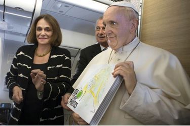 En route pour Bangui le 30 novembre, le pape François tient dans les mains notre livre remis par Caroline Pigozzi.