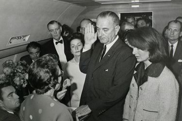 Vice-président au moment de l&#039;assassinat, Lyndon B. Johnson prête serment alors que l&#039;avion présidentiel n&#039;a pas encore décollé de Dallas. Jackie Kennedy se tient à ses côtés, la robe ensanglantée. 