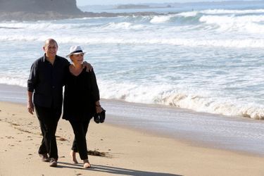 Promenade en amoureux pour Jean-Yves LE DRIAN et son épouse Maria VADILLO, pieds nus, ses chaussures à la main, sur la plage de GUIDEL dans le Morbihan le 8 août 2015.