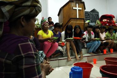  Des villageois réfugiés dans une Église, reconvertie en abri de fortune, prient avant de prendre leur dîner, le 3 novembre.  