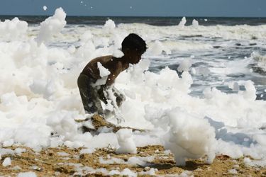 Malgré l&#039;odeur âcre dégagée par la mousse provoquée par des agents polluants, des enfants jouaient à se rouler dedans et à se prendre en photo, sur les plages du Chennai, en Inde.