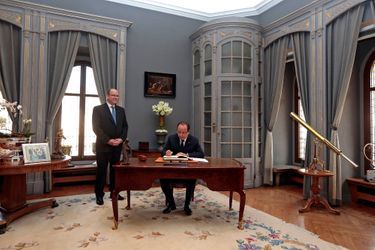 Dans le palais princier, François Hollande signe le livre d'or.