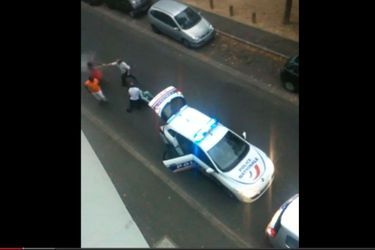 Capture d&#039;écran à 1:23 de la vidéo montrant un policier utilisant une bombe lacrymogène. 