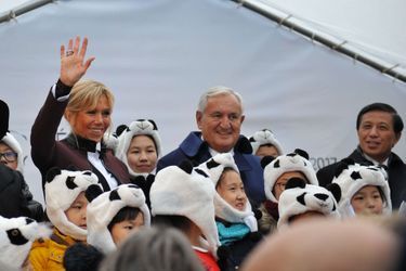 Des enfants avec des bonnets panda entourent Brigitte Macron, Jean-Pierre Raffarin et Zhang Yesui.