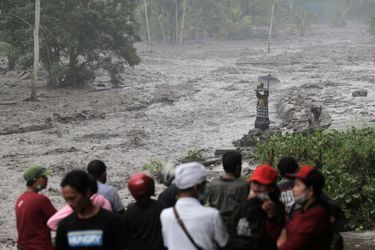 Des villageois observent l&#039;écoulement des résidus du volcan mêlés à une rivière, Bali, le 28 novembre 2017