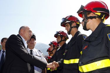 Le ministre de l'Intérieur Gérard Collomb salue les pompiers samedi, en Corse. 