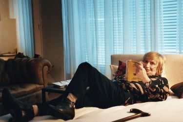 Françoise Sagan sur son lit en train de lire