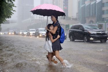 Une femme et son enfant pendant une inondation en Chine, dans la ville de Shenzhen.