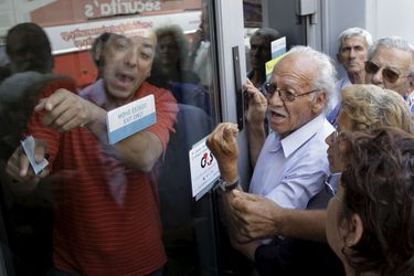 Des retraités tentent d'obtenir leurs pensions, lundi, en Crète, devant une banque fermée.