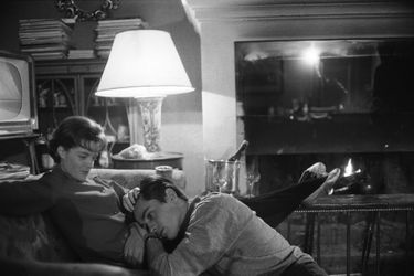 Romy SCHNEIDER et Alain DELON dans leur hôtel particulier de l&#039;avenue de Messine à PARIS : Romy assise sur un canapé dans le salon, caressant la tête d&#039;Alain posée sur ses jambes, l&#039;acteur assis à ses pieds.