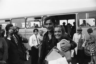 Alain DELON souriant serrant contre lui Romy SCHNEIDER qu'il est venu accueillir à l'aéroport de NICE sous les flashs des photographes. 